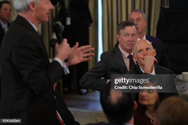 Colorado Governor John Hickenlooper and Florida Governor Rick Scott listen to Governor Asa Hutchinson speak during a business session with fellow...