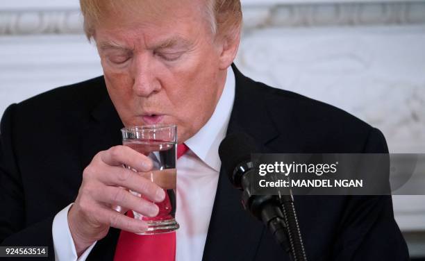 President Donald Trump takes a sip of water during the 2018 White House business session with governors in the State Dining Room of the White House...
