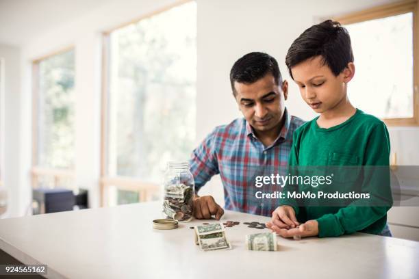 father and son counting money at home - kids money fotografías e imágenes de stock