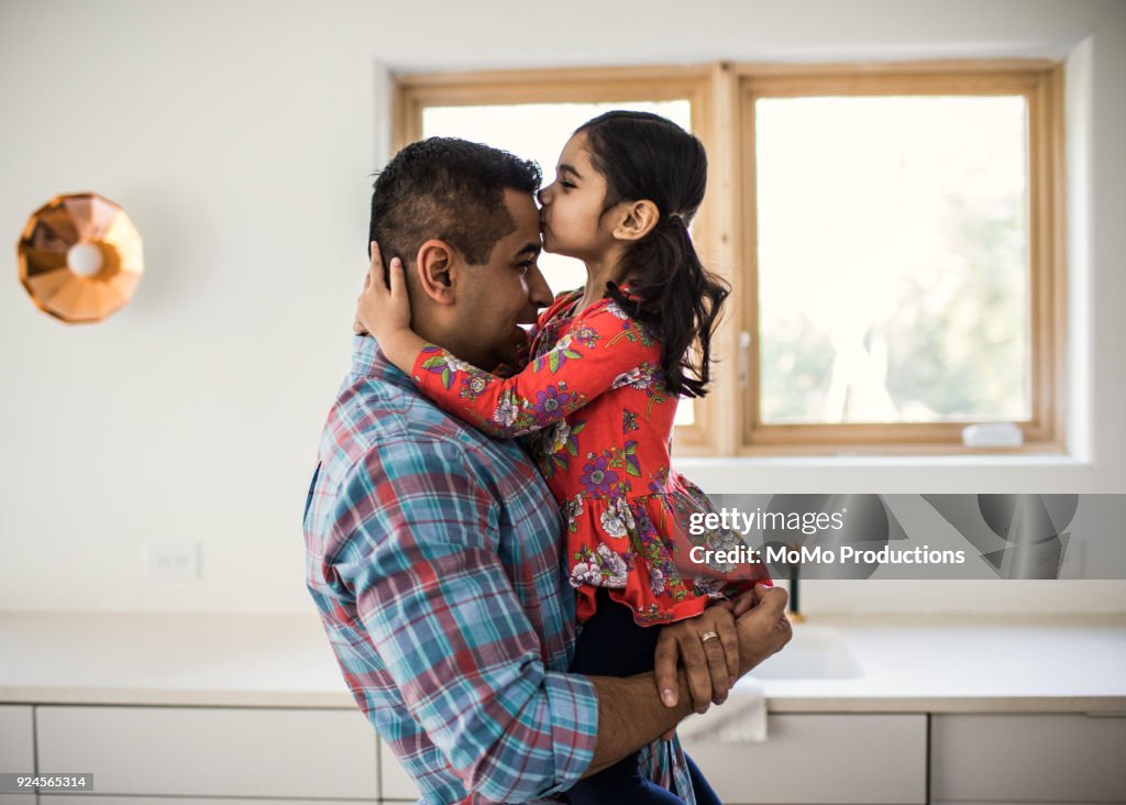 Daughter kissing father at home