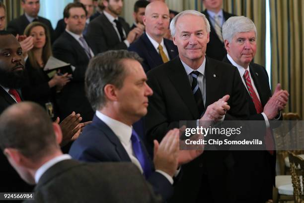 Michigan Governor Rick Snyder , Arkansas Governor Asa Hutchinson and fellow state governors stand and applaud at the conclusion of a business session...