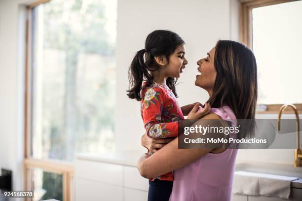 mother and daughter embracing in kitchen - indian mother and child stock pictures, royalty-free photos & images