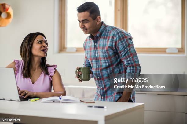 husband and wife using laptop in kitchen - working wife stock pictures, royalty-free photos & images