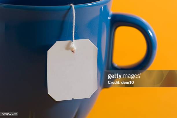 teebeutel label hängen von einem kaffeebecher oder teebecher - teebeutel stock-fotos und bilder