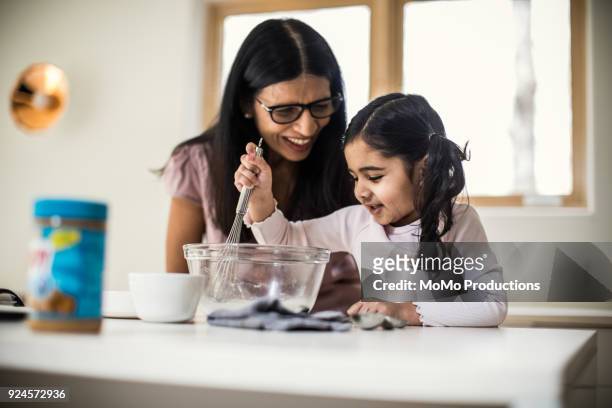 grandmother and granddaughter cooking at home - mixing bowl stock pictures, royalty-free photos & images