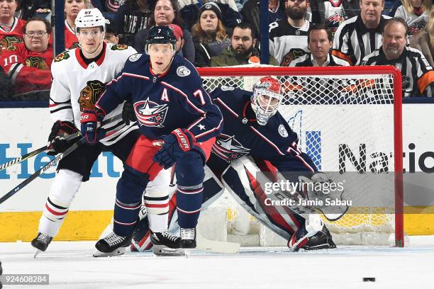 Tommy Wingels of the Chicago Blackhawks and Jack Johnson of the Columbus Blue Jackets battle for position in front of goaltender Sergei Bobrovsky of...