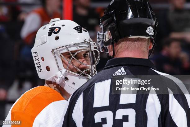 Referee Kevin Pollock chats with Petr Mrazek of the Philadelphia Flyers during a game against the Ottawa Senators at Canadian Tire Centre on February...