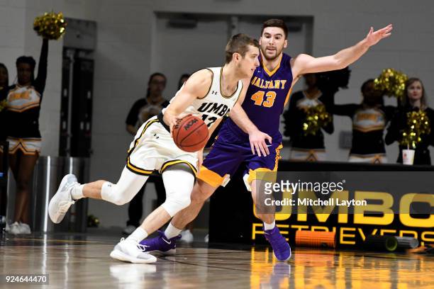 Joe Sherburne of the UMBC Retrievers dribbles around Greig Stire of the Albany Great Danes during a college basketball game at the Events Center on...