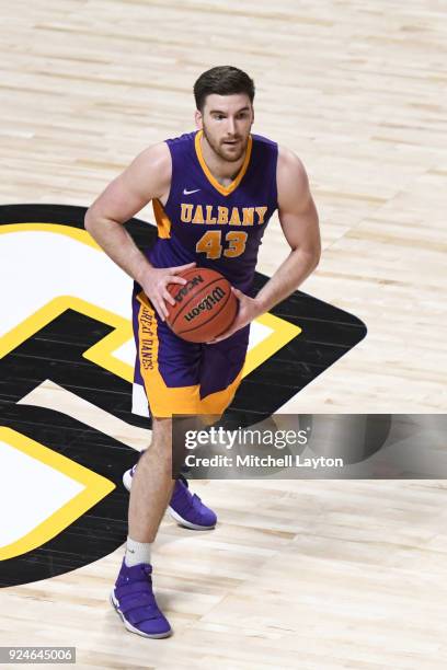 Greig Stire of the Albany Great Danes looks to pass the ball during a college basketball game against the UMBC Retrievers at the Events Center on...