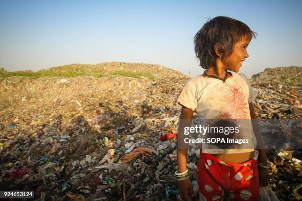 Child from the slum seen standing on a large pile of rubbish. Over 25 million people live in Delhi, India. What is particularly problematic in India...