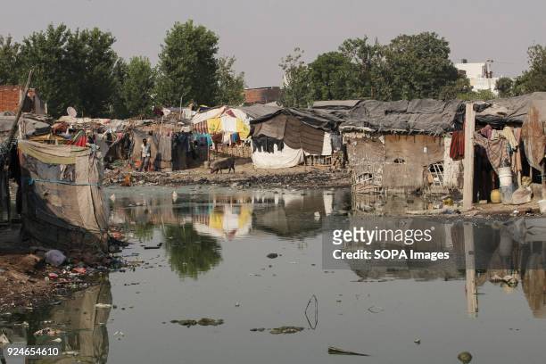Local slum seen next to extreme dirty water. Over 25 million people live in Delhi, India. What is particularly problematic in India is environmental...