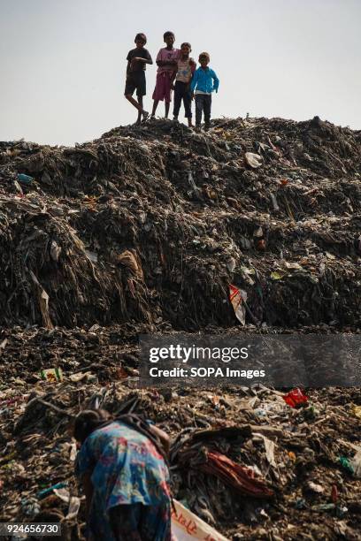 Group of children from the slum seen spending their afternoon playing on a pile of rubbish. Over 25 million people live in Delhi, India. What is...