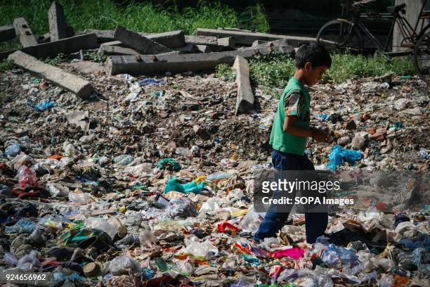 Child from the slum seen walking on a pile of rubbish. Over 25 million people live in Delhi, India. What is particularly problematic in India is...