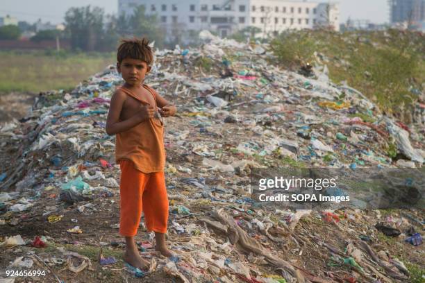 Child from the slum seen standing on a large pile of rubbish. Over 25 million people live in Delhi, India. What is particularly problematic in India...