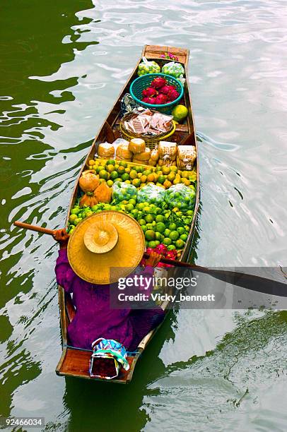 lady selling fruit from her boat at floating market, thailand - floating market stockfoto's en -beelden