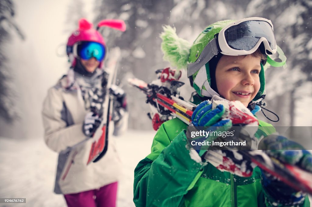 Kids carrying skis on a beautiful winter day