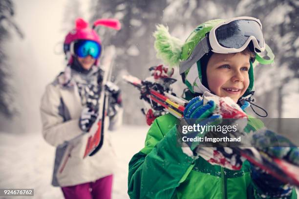 kids carrying skis on a beautiful winter day - family skiing stock pictures, royalty-free photos & images