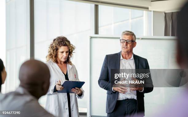 healthcare workers giving presentation at office - doctor presentation stock pictures, royalty-free photos & images