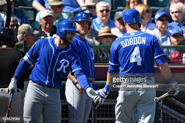 Alex Gordon of the Kansas City Royals is congratulated by Tyler Collins after hitting a sacrifice fly in the first inning of the spring training game...