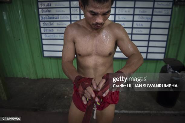 This photo taken on January 31, 2018 shows the current World Boxing Council mini-flyweight champion, Wanheng Menayothin, adjusting his handwraps...