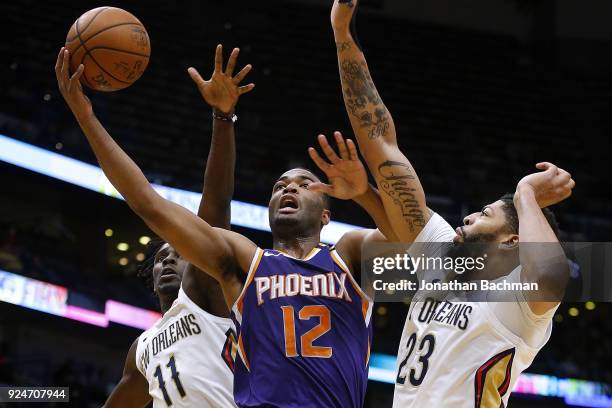 Warren of the Phoenix Suns shoots against Anthony Davis of the New Orleans Pelicans and Jrue Holiday during the first half at the Smoothie King...