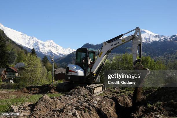 Construction site. Mechanical digger at work in a garden. France. .