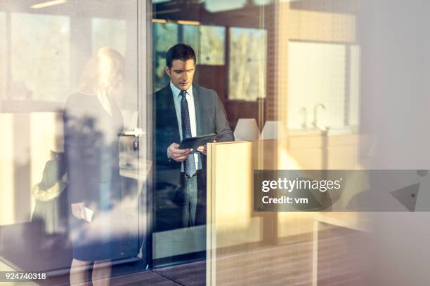 businessman showing his partner something on a digital tablet - hedge fund stock pictures, royalty-free photos & images