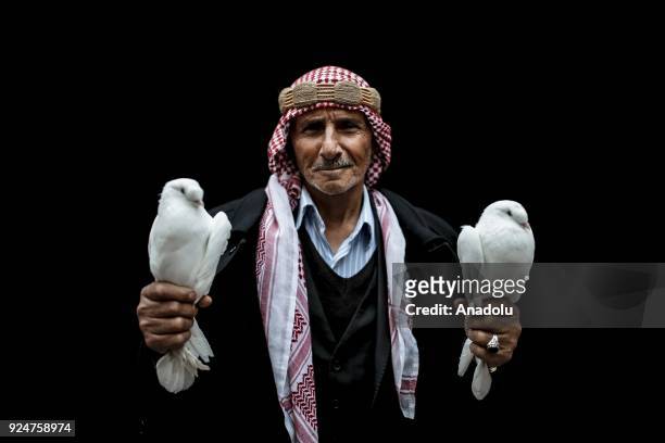 Year-old bird lover Mahmut Cetin who breeds birds for 50 years poses for a photo with doves at a pigeon market in Turkey's southern Sanliurfa...