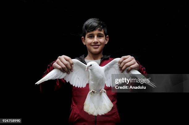 Year-old bird lover Abdullah Bozdag who breeds birds for 6 years poses for a photo with a dove at a pigeon market in Turkey's southern Sanliurfa...