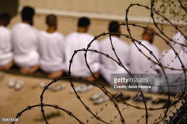 Group of detainees kneels during an early morning Islamic prayer in their camp at the U.S. Military prison for "enemy combatants" on October 28, 2009...