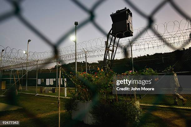 An American guard walks along the exterior of a camp for Chinese Uigur detainees at the U.S. Military prison for "enemy combatants" on October 28,...