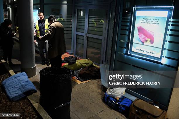 Volunteers of the French charity Les Restos du Coeur speak with a homeless man in a street of the eastern French city of Strasbourg, on February 26,...