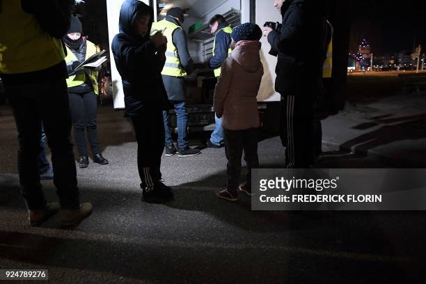 Volunteers of the French charity Les Restos du Coeur distribute hot meals to homeless people in the streets of the eastern French city of Strasbourg,...