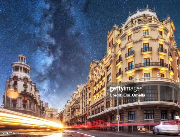 car trails in gran via at night with milky way. madrid. spain - madrid stock pictures, royalty-free photos & images