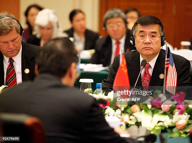 Commerce Secretary Gary Locke listens to a speech made by China's Vice Premier Wang Qishan during the opening ceremony of the 20th China and US Joint...