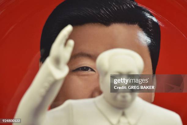 Decorative plate featuring an image of Chinese President Xi Jinping is seen behind a statue of late communist leader Mao Zedong at a souvenir store...