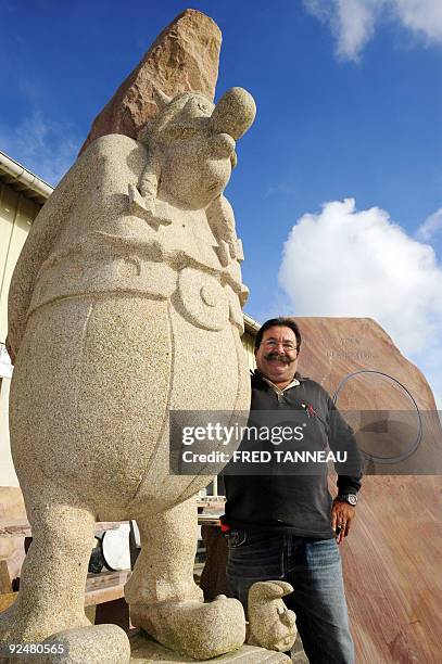 French sandstone-cutter Manuel Mendes poses next to a statue he made which represents comic character Obelix on October 13, 2009 in the western...