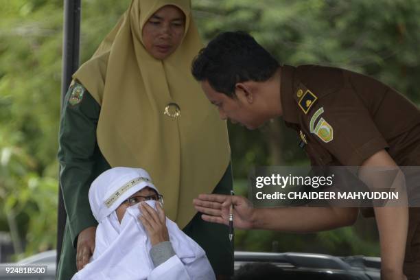 Tjia Nyuk Hwa an Indonesian Christian prepares to be publicly flogged outside a mosque in Banda Aceh on February 27 for playing a children's...