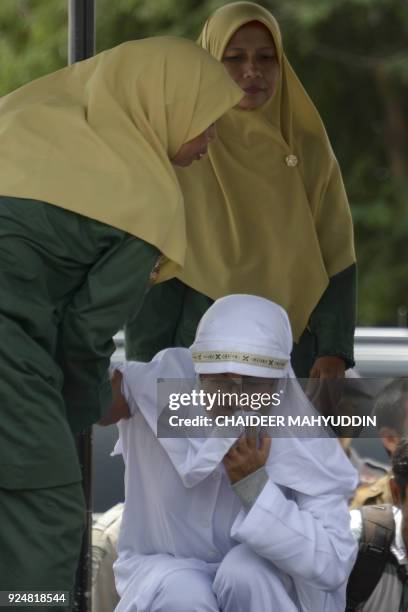 Tjia Nyuk Hwa an Indonesian Christian prepares to be publicly flogged outside a mosque in Banda Aceh on February 27 for playing a children's...