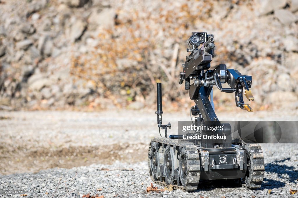 Policía Swat oficial utilizando una unidad de robots de brazo mecánico bomba eliminación