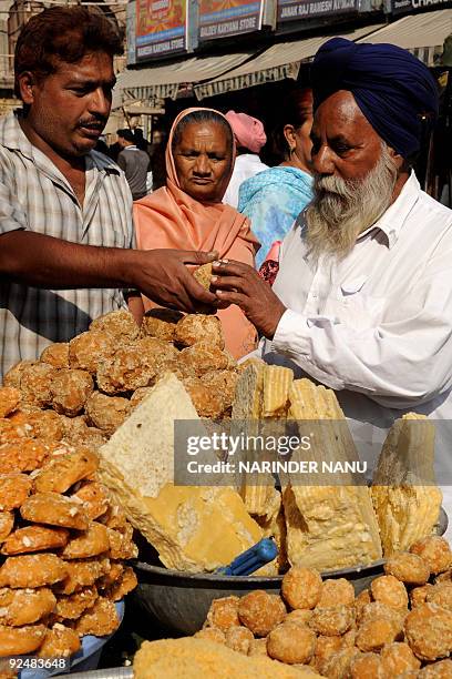 Indian vendor Baldev Arora sells jaggery in Amritsar on October 29, 2009. Jaggery, also known as gur, is made from sugarcane juice which is in heavy...