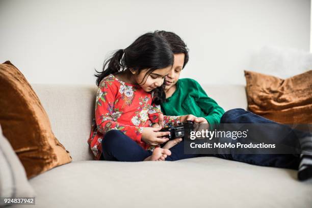 Brother and sister using video game controller