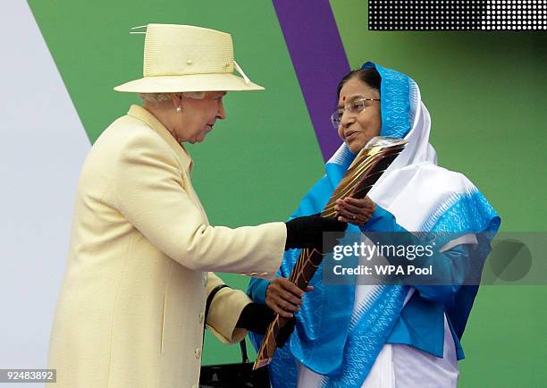 Britain's Queen Elizabeth II presents India's President Prathibha Devi Singh Patil with the baton to launch the XIX Commonwealth Games Queen's Baton...