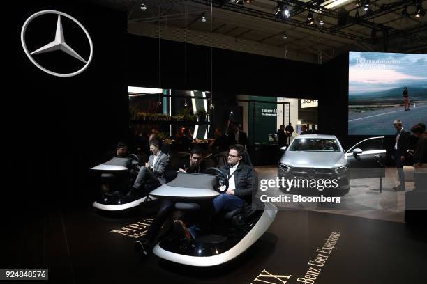 Attendees test out the MBUX intelligent multimedia system on the Mercedes-Benz AG stand during day two of the Mobile World Congress in Barcelona,...