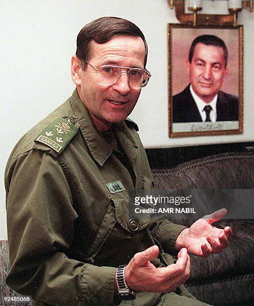 Canadian commander Baril posess 18 November beside a portrait for the Egyptian President Hosni Mubarak upon his stopover in Cairo on his way to...