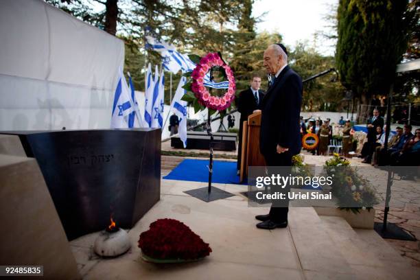 Israeli President Shimon Peres stands by the grave of Israeli Prime Minister Yitzhak Rabin during a memorial ceremony marking the 14th anniversary of...