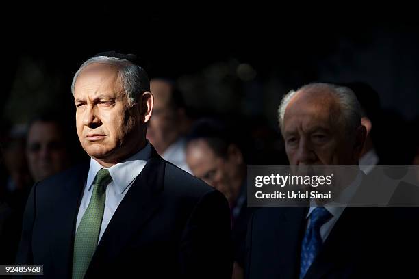 Israeli Prime Minister Benjamin Netanyahu stands next to Israeli President Shimon Peres during a memorial ceremony marking the 14th anniversary of...