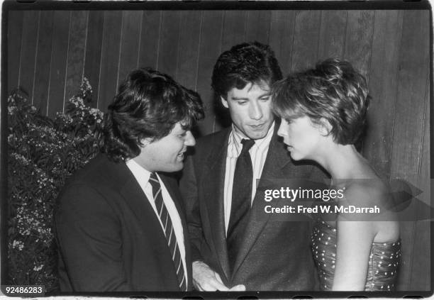 American magazine publisher Jann Wenner talks with actors John Travolta and Jamie Lee Curtis, stars of the film 'Perfect,' May 29, 1985. The film was...