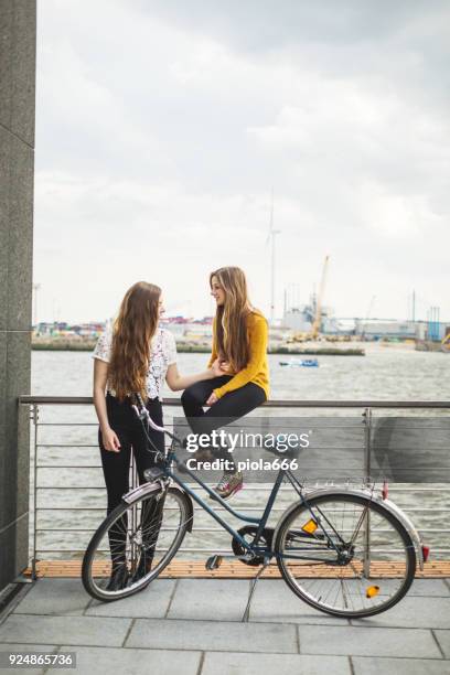 frauen genießen die sonne in der stadt zusammen - happy sprong two persons sun stock-fotos und bilder