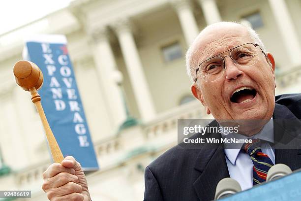 Rep. John Dingell wields the gavel used when he chaired the committee that passed Medicare legislation in 1965 during an event at the U.S. Capitol...